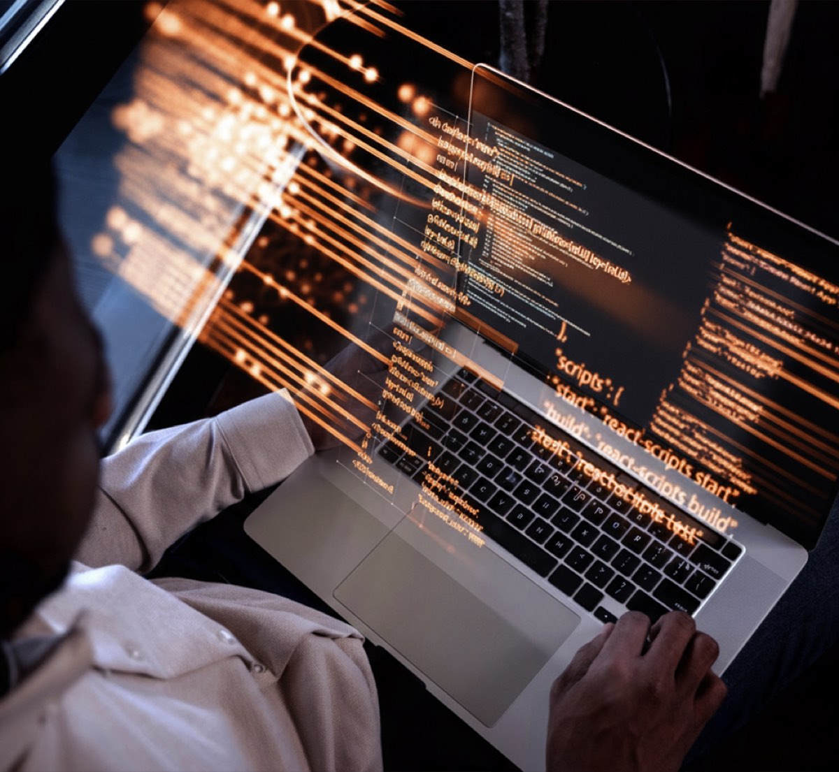 Developer writing code on a laptop with glowing script overlay